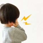 歯痛で頬を押さえている男の子