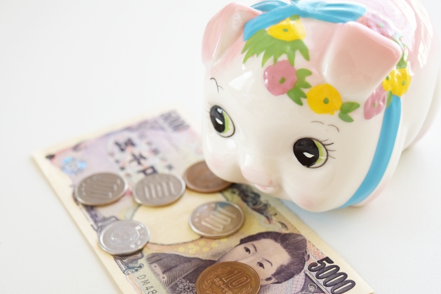 五千円札と小銭と豚の貯金箱