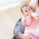 ママに抱っこされてミルクを飲んでいる赤ちゃんの画像