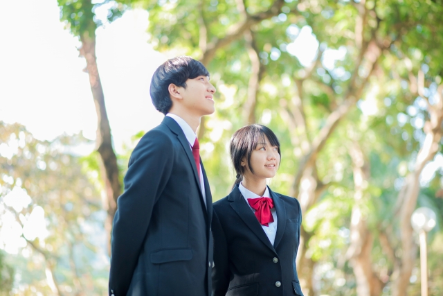 昼間の公園の中での中学生カップル