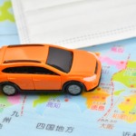 日本地図の上に玩具の車を走らせている
