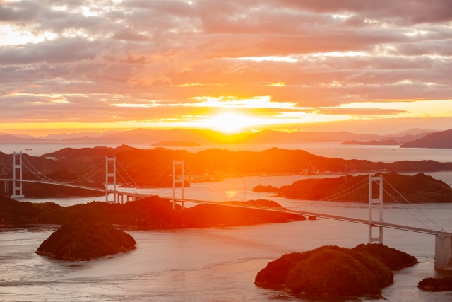 夕日が出ている空に来島海峡大橋
