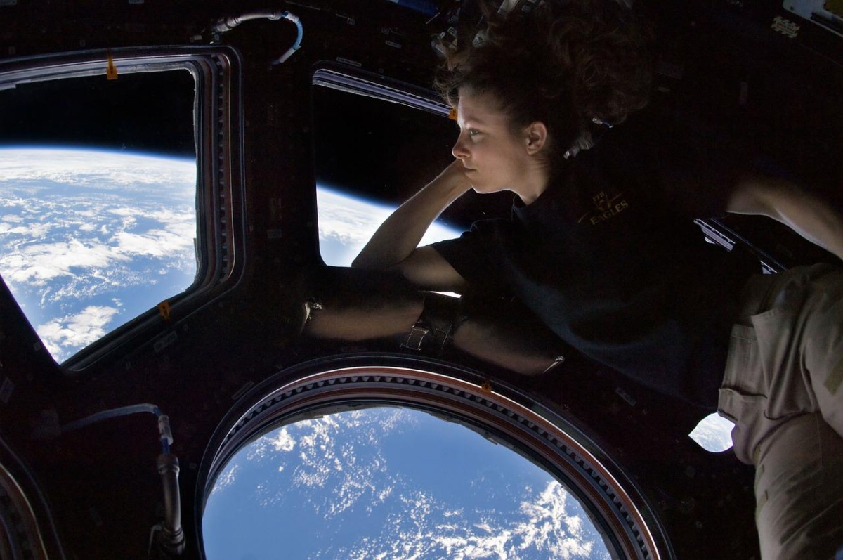  ロケットの中から横たわって地球を見る女性
