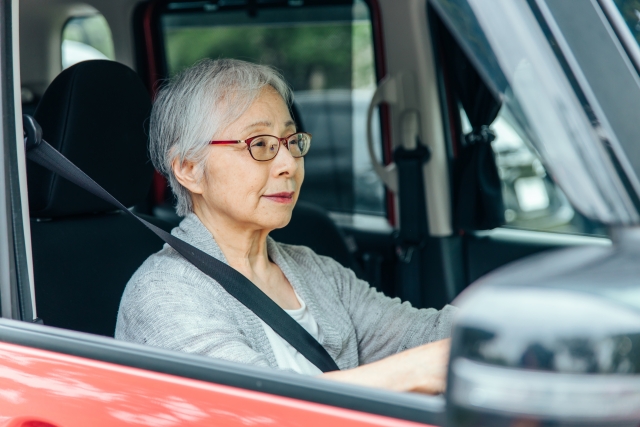 車を運転している女性の高齢者