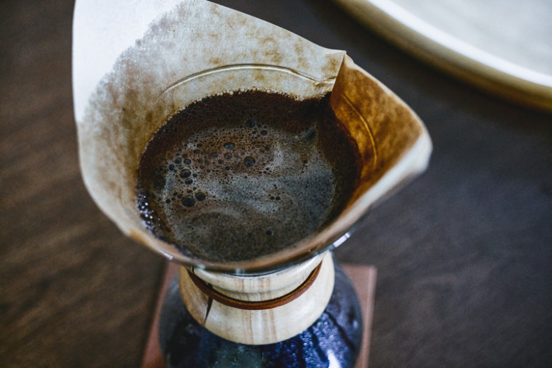 コーヒーのペーパードリッパーに挽かれたコーヒー豆が入っている。その下にコーヒーサーバーが置いてありコーヒーを抽出している