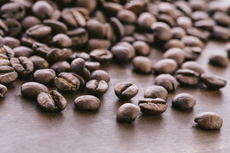 焙煎されたコーヒー豆が70粒ほど木製の板の上においてある