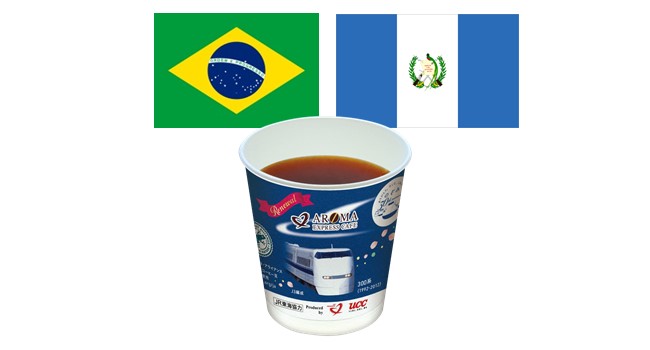 ブラジルとグアテマラの国旗、その前に紙コップに入ったコーヒーがある